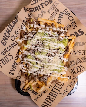 Loaded fries finished with fresh toppings and sauce