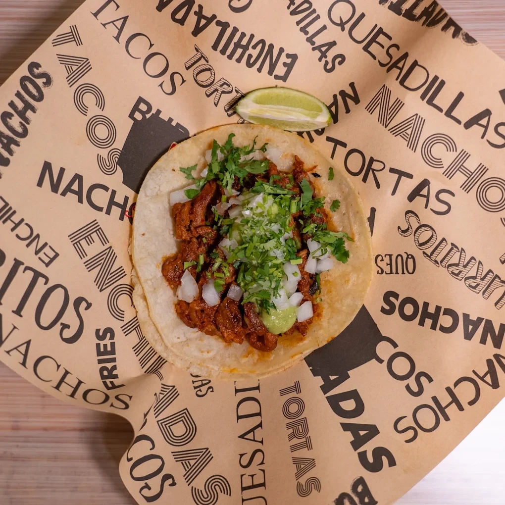 Tacos topped with guacamole, onion and cilantro