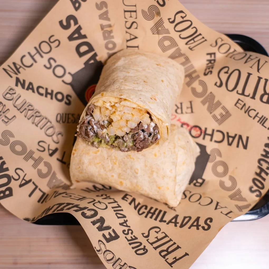 A wrapped burrito ready to serve on branded tray paper